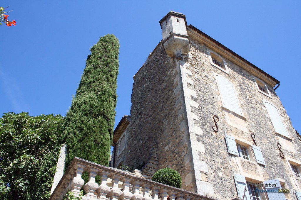 Joli bâtiment avec un cyprès.