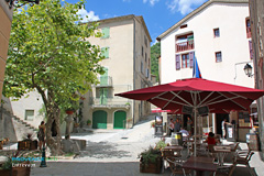 Entrevaux, terrasse sur la place avec la fontaine Entrevaux, terrasse sur la place avec la fontaine